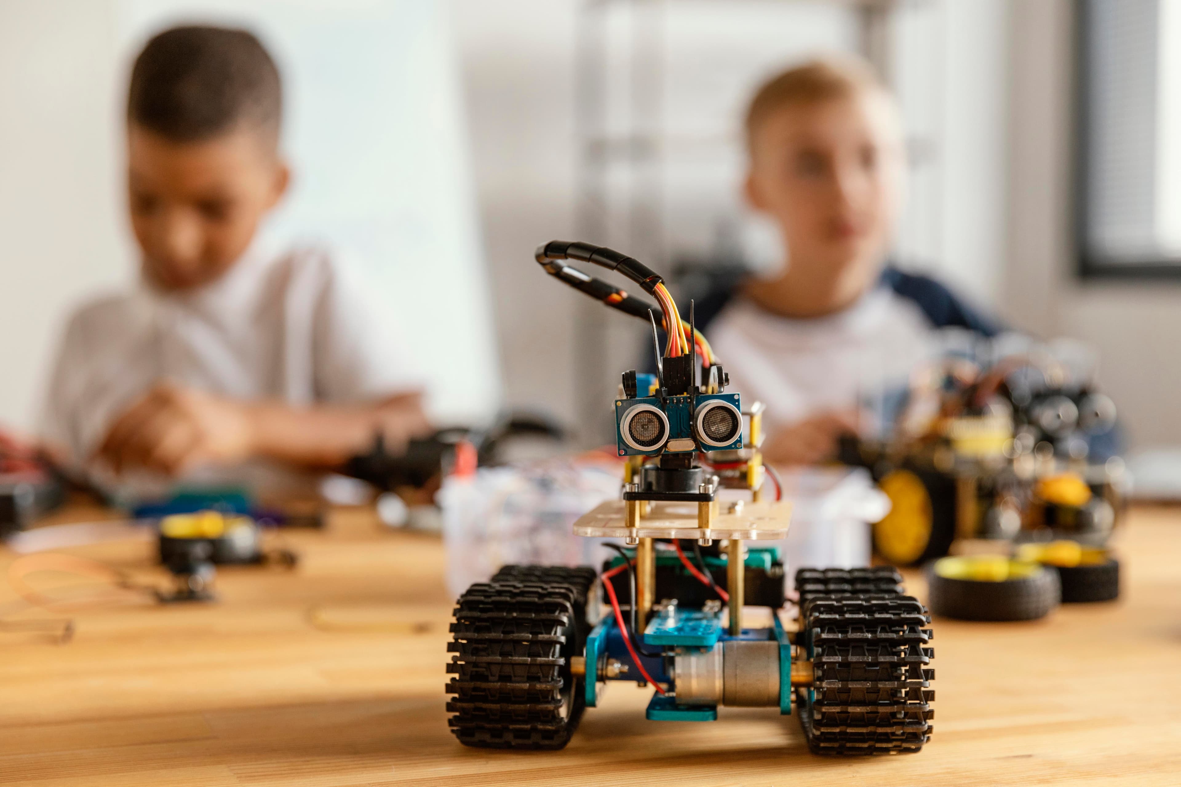 Children building and programming a tracked robot with an ultrasonic sensor