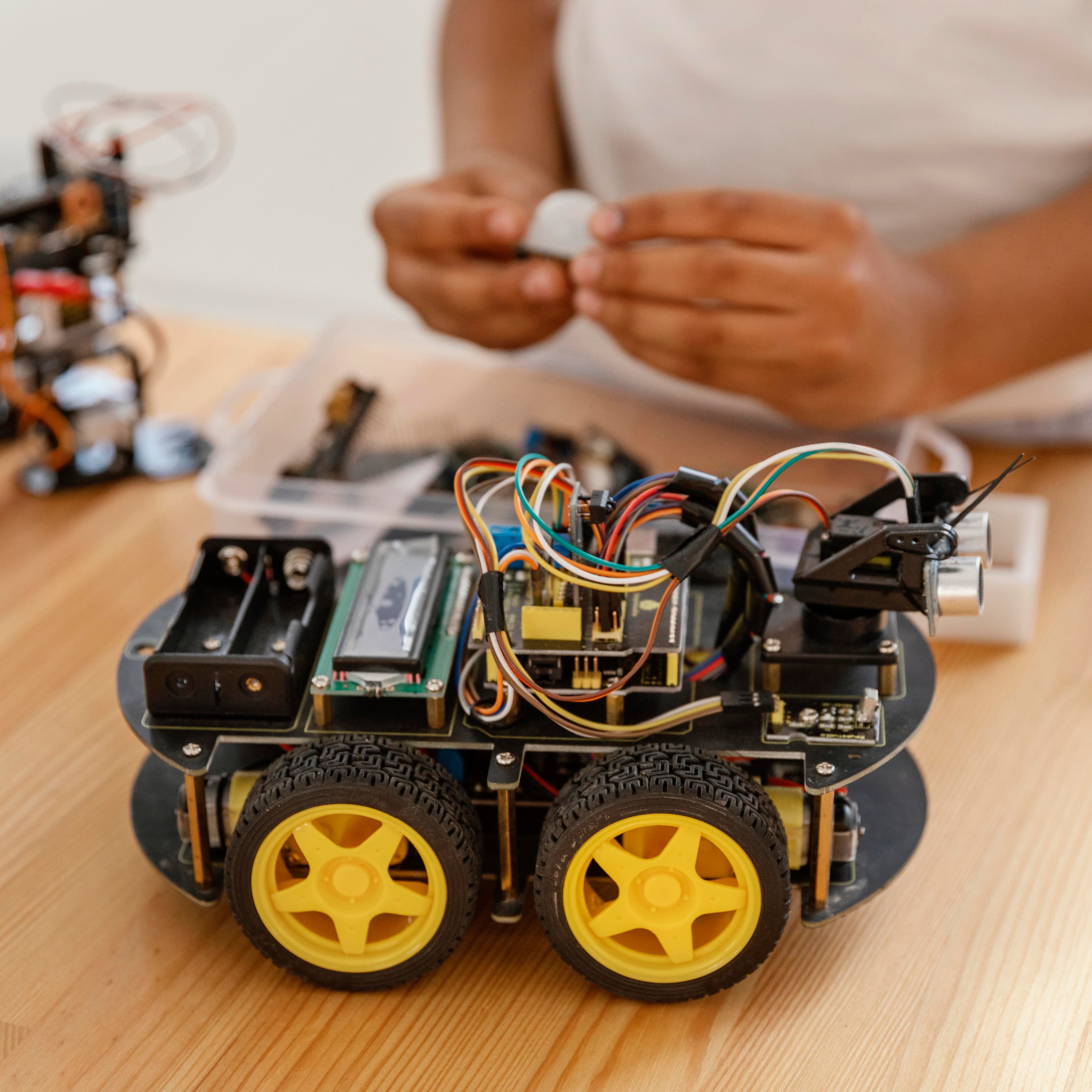 Four-wheel robot car with microcontroller and sensors on a STEM lab workbench